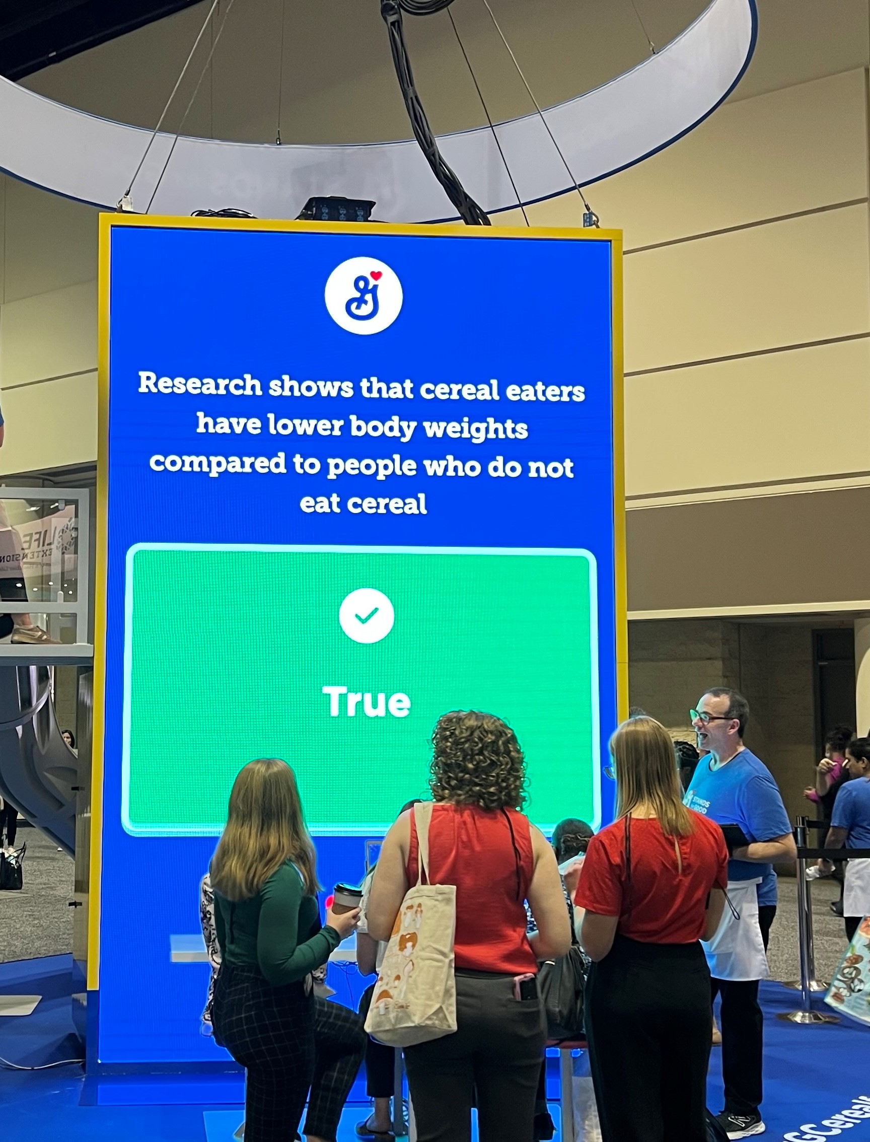 FNCE booth screen with attendees playing a quiz