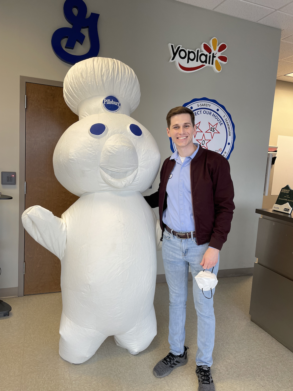 Adam Anderson, General Mills employee, standing with the Pillsbury Doughboy