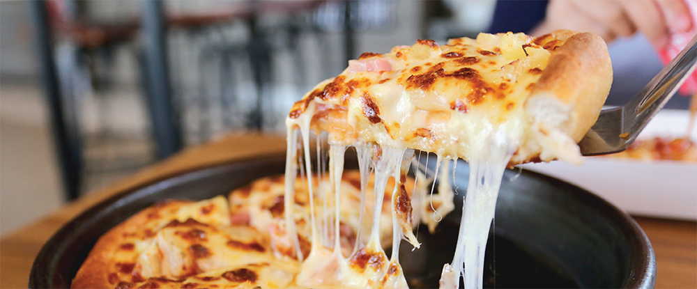 Slice of pan pizza being lifted out of the pan